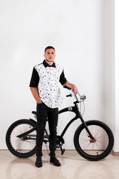 Teenager posing with a vintage style retro clothing and a bike.