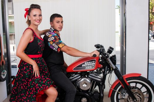 Close up of a couple using vintage clothing on a motorbike.