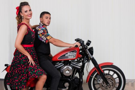 Close up of a couple using vintage clothing on a motorbike.
