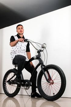 Teenager posing with a vintage style retro clothing and a bike.