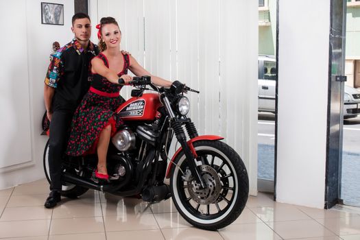 Close up of a couple using vintage clothing on a motorbike.