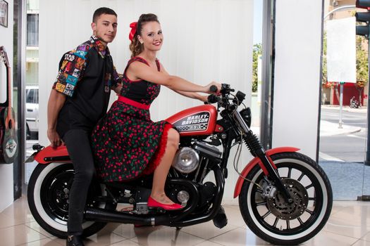 Close up of a couple using vintage clothing on a motorbike.