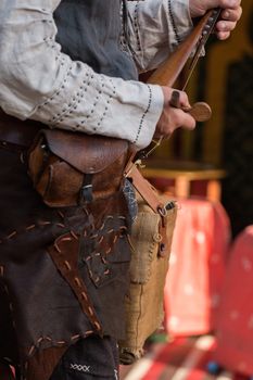 Close view detail of a man playing a medieval rebec instrument.