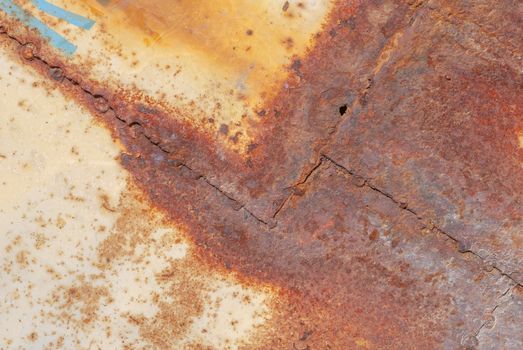 rusty iron surface covered with old chipped yellow color paint, which has long been influenced by different climatic conditions