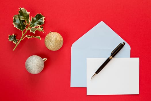 Christmas letter and pen over a red background with decorations