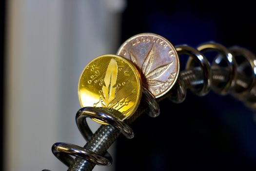 Digital currency physical gold metal feather coin with red heart. Cryptocurrency concept.
