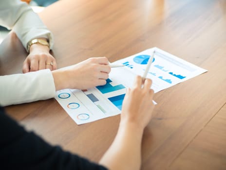 Business people pointing at diagrams discussing financial reports at workplace