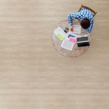 Businessman working with finance documents at office with laptop, and graph data papers on his desk, top view with copy space