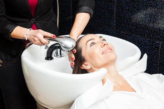 White woman getting a hair wash procedure in a beauty salon