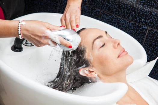 White woman getting a hair wash procedure in a beauty salon