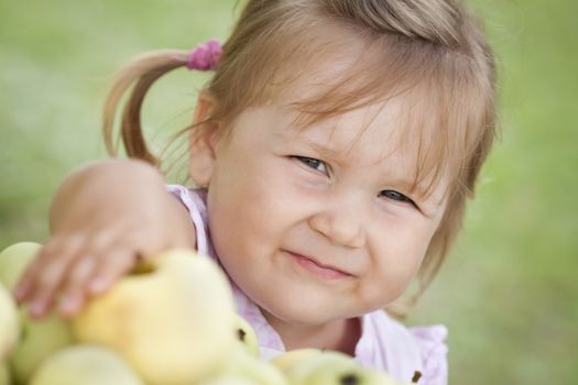 Cute little girl reaches for the green apple