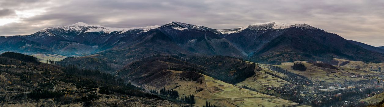 panorama of mountainous countryside in late autumn. great Borzhava mountain ridge with snowy tops at sunrise