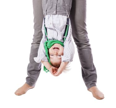 Laughing boy hanging upside down isolated on white