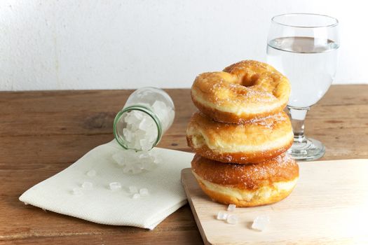 donuts glazed with a sugar icing on a rustic wooden table