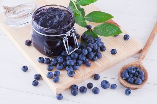 Blueberry jam and fresh fruits on the white wooden table