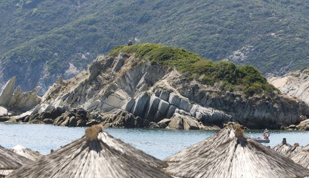 Beach with straw umbrellas in Greece, Chalkidiki, Sithonia.