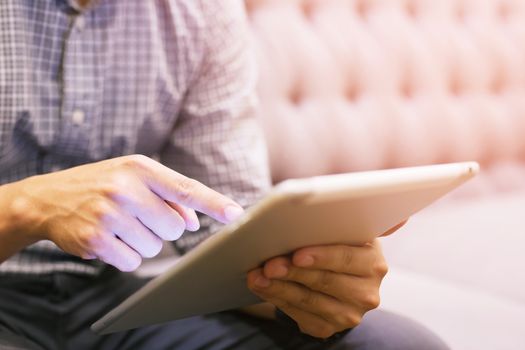 VIP seat close up hands of young man lifestyle using tablet. living sit on sofa luxury.