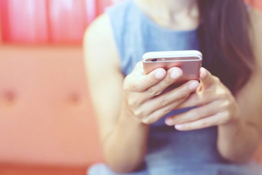 lifestyle woman close up hands using mobile phone Sit on a sofa color red.