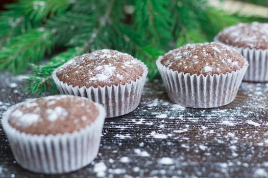 Christmas and New Year winter holiday composition of three cakes on snowbound wooden space background with green fir tree branches