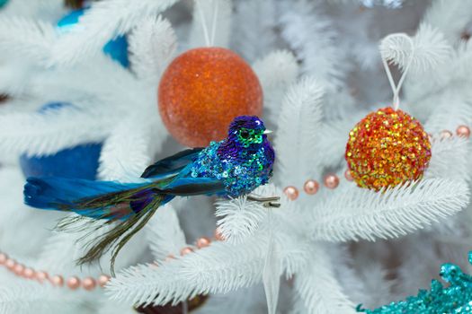 Christmas decoration, bird, orange and golden balls on white tree