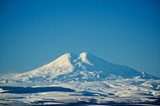 Two Beautiful Snowy Mountain Peaks of Caucasus Range against Blue Sky in Sunny Winter Day Outdoors