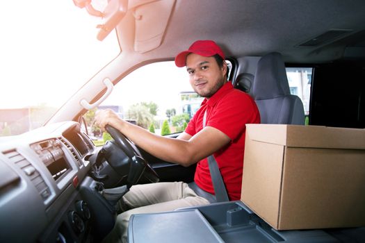 delivery service courier ringing the house doorbell with boxes in hands