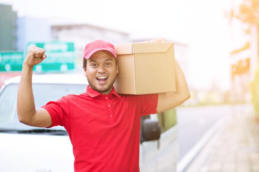 delivery service courier ringing the house doorbell with boxes in hands