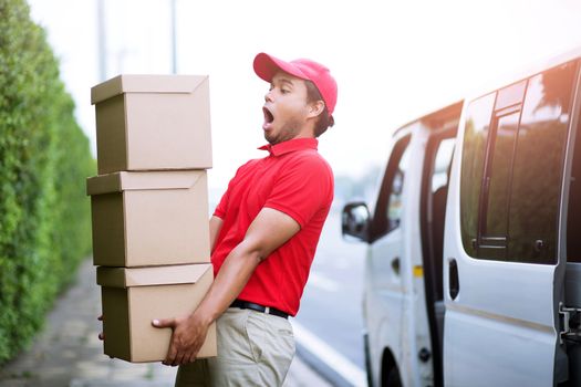 delivery service courier ringing the house doorbell with boxes in hands