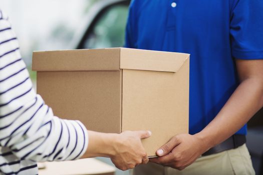 delivery of a package through a service. hand accepting a delivery of boxes from deliveryman. All services are impressive.