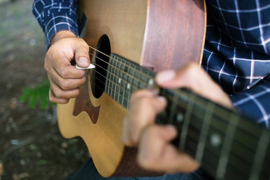 Acoustic guitar guitarist playing. Musical instrument with performer hands in parks.