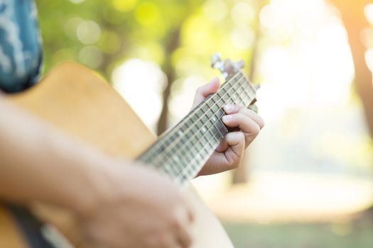 Acoustic guitar guitarist playing. Musical instrument with performer hands in parks.