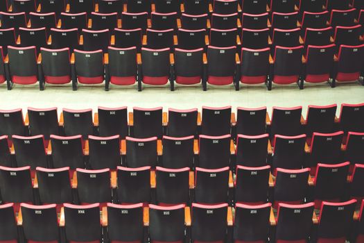 Empty comfortable red black seats with numbers in cinema / theater empty seats.