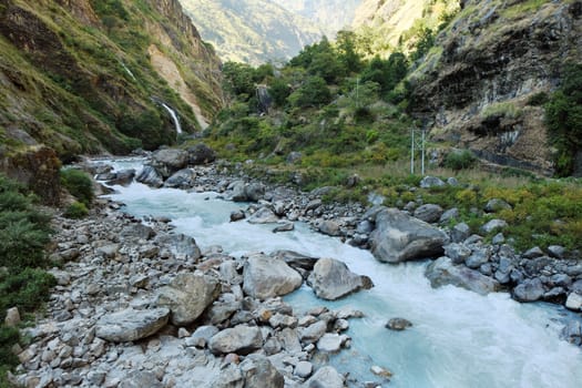 Rapids and waterfall in the narrow place of the mountain river in the Himalayas