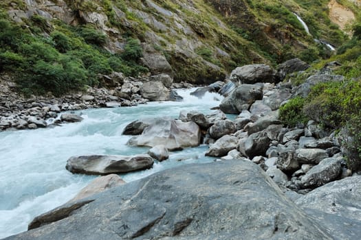 Rapids and waterfall in the narrow place of the mountain river in the Himalayas