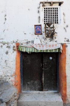 Door with amulets in the ancient Buddhist mountain village in Nepal