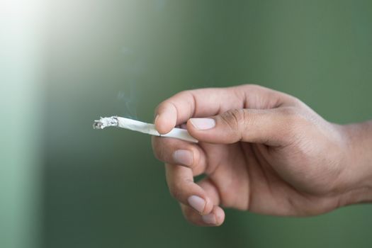 The man smoking a cigarette. Cigarette smoke spread.