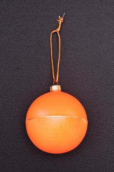 Symbol Christmas and new year, Orange Christmas ball on a black background.