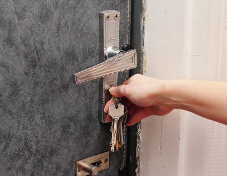 Female hand open the metal door key.