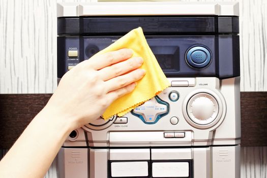 A woman holds a thorough cleaning cloth musical center.