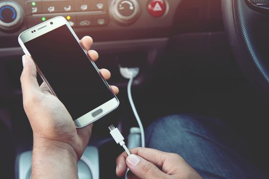 Power plug charging phone in car.