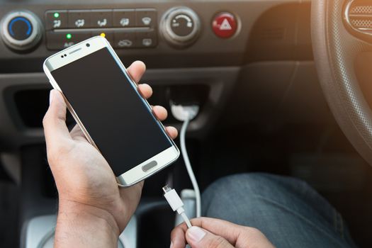 Power plug charging phone in car.