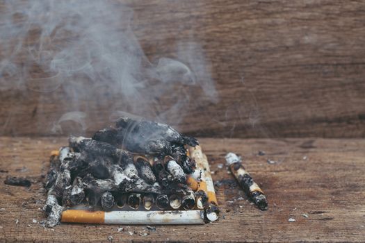 burning cigarette In the wood floor. Campaign no smoking concept.