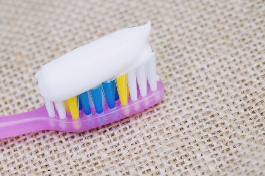 Toothbrush with toothpaste on a sackcloth background