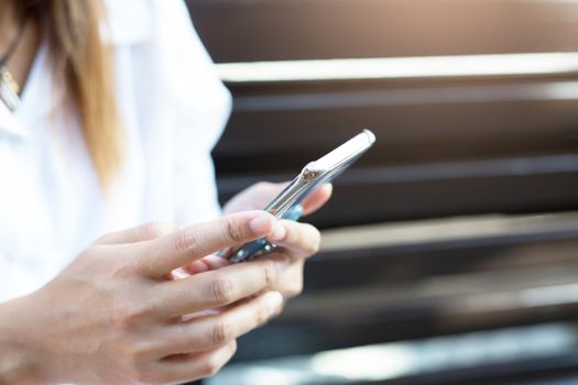 woman using a mobile phone searching for Telephone signal on a mountain landscape background. Digital communication. Texting message with friends in social network