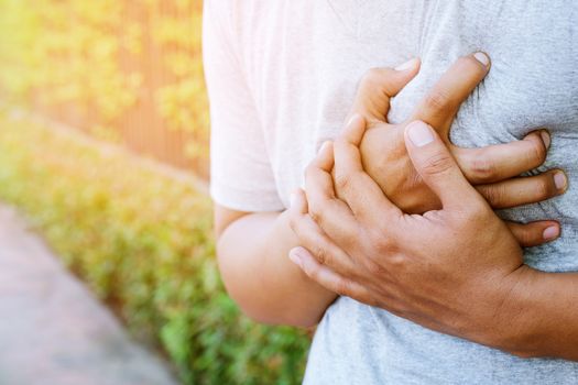 Man having chest pain - heart attack outdoors. or Heavy exercise causes the body to shocks heart disease