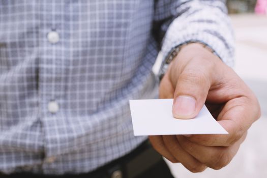 business man in hand hold show blank white card mock up with rounded corners. Plain call-card mock up template holding arm. Plastic credit name card display front.