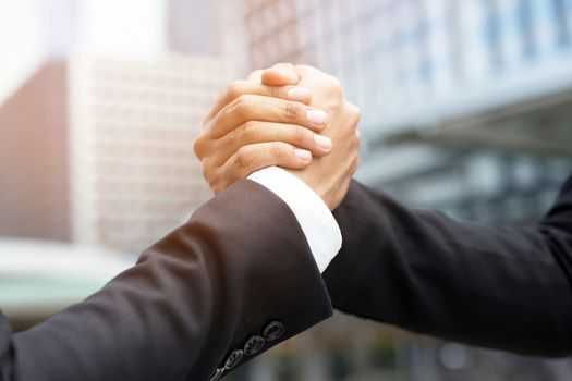 companionship hand clasping success trust, confident concept. or Closeup of a businessman hand between two colleagues on outdoor building.