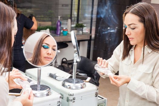 White woman removing makeup in front of mirror at beauty salon