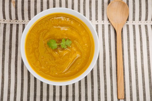 Bowl of pumpkin soup on black stone background.