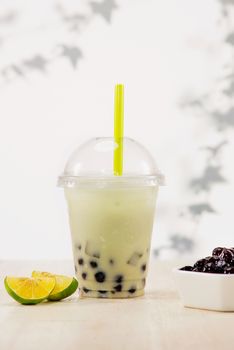 Lemon bubble boba tea with milk and tapioca pearls in plastic cup